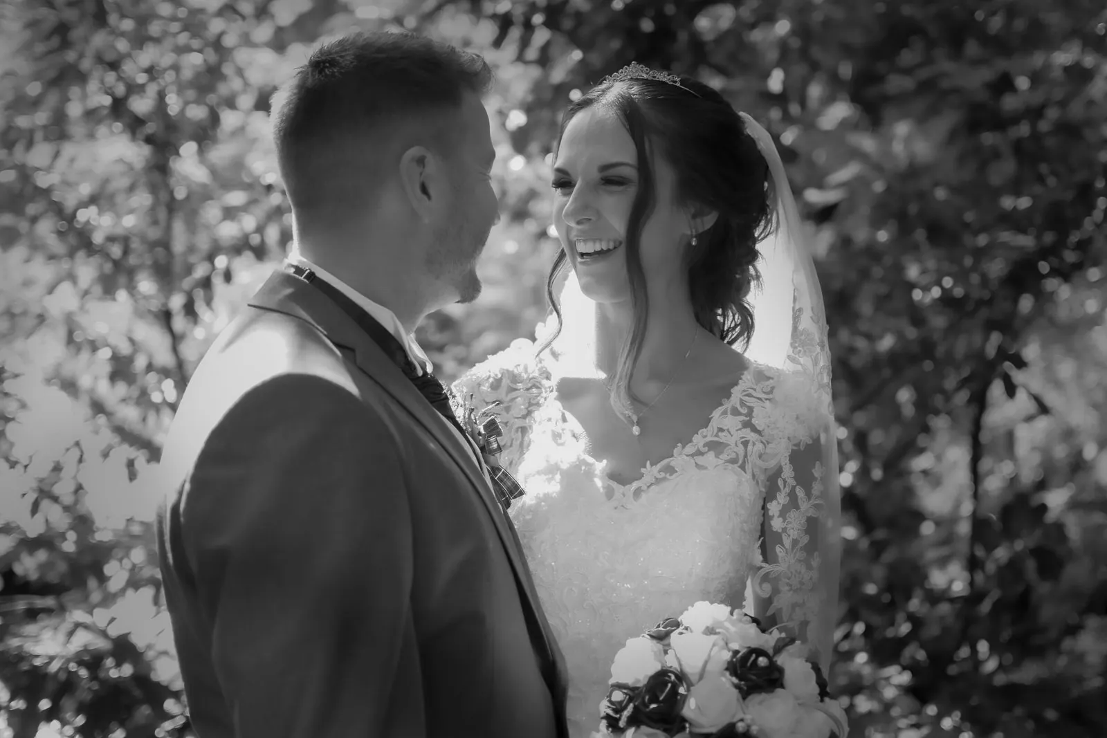 Bride and groom laughing together in black and white at a Lancashire wedding