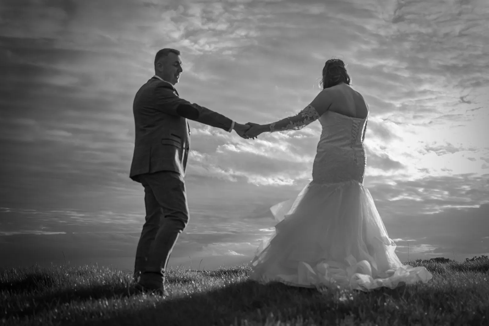 Couple silhouetted on high ground against a bright Lancashire sky